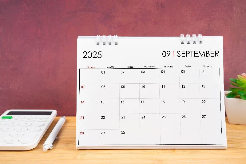September 2025 white calendar and a calculator with a pen