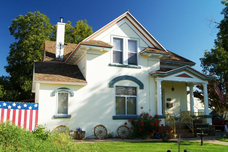 Suburban house with a well-kept front yard and patriotic decorations adorning the porch.